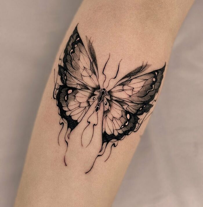 female butterfly tattoo on forearm